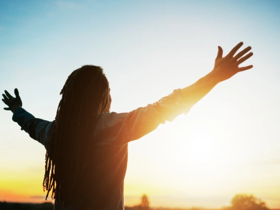 Woman raising her hands to the sun