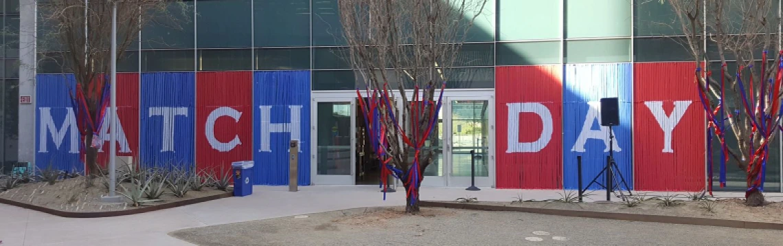 Streamers make up a banner that reads “Match Day” in tall glass windows at the UArizona College of Medicine – Phoenix.