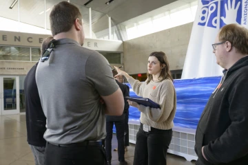 Kate Chartrand, manager of student engagement for the University of Arizona College of Medicine – Phoenix, talks to a group of people inside the Arizona Science Center in Phoenix.